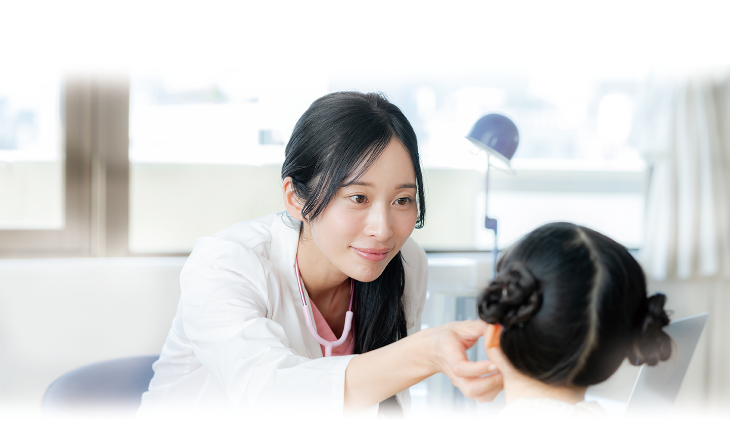 笑顔で子どもを診察する医師
